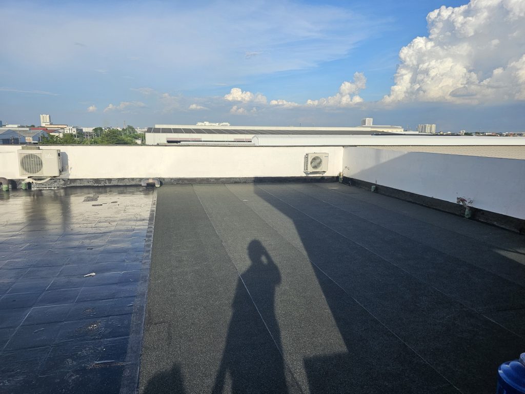 Old roof tiles primed (left) next to installed mineral-surfaced membrane (right)
