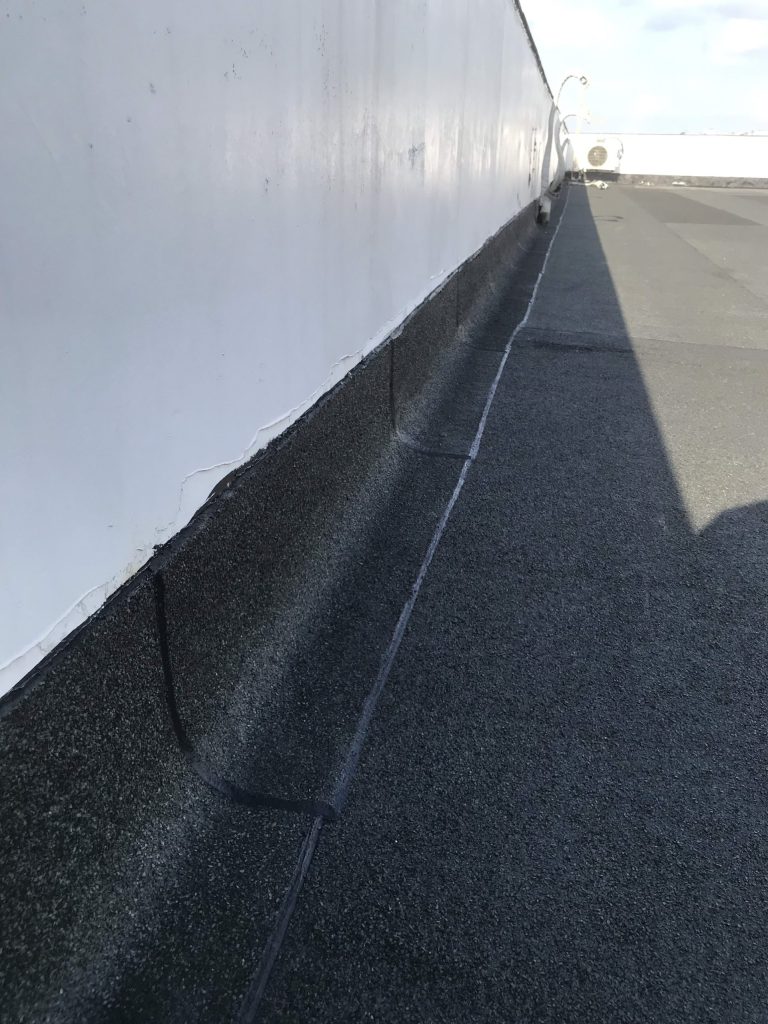 Mineral-surfaced membrane turned up the parapet wall to 300mm