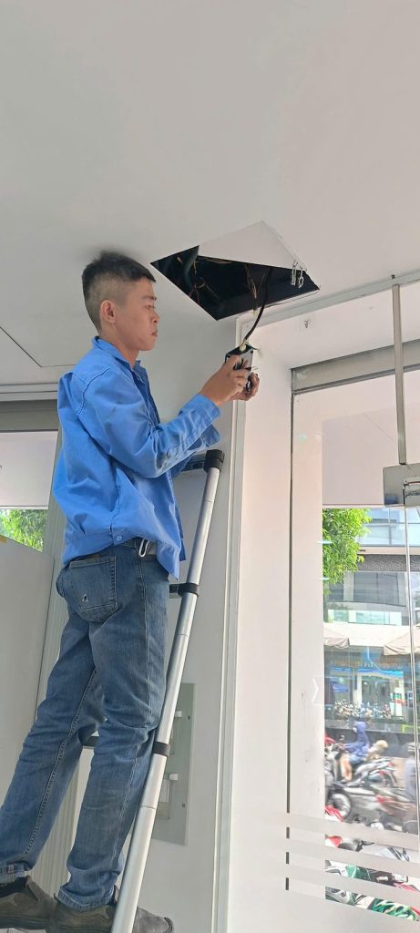 Checking signal wiring above the ceiling of a bank office
